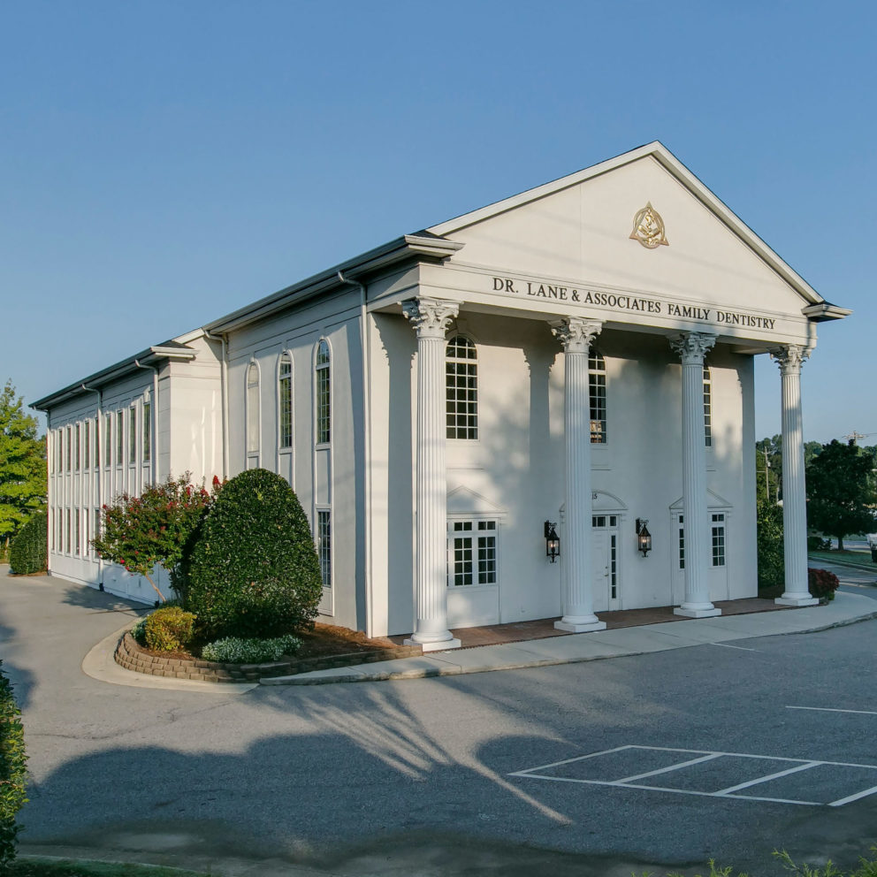 Big white dentist office with columns in Angier NC during Spring