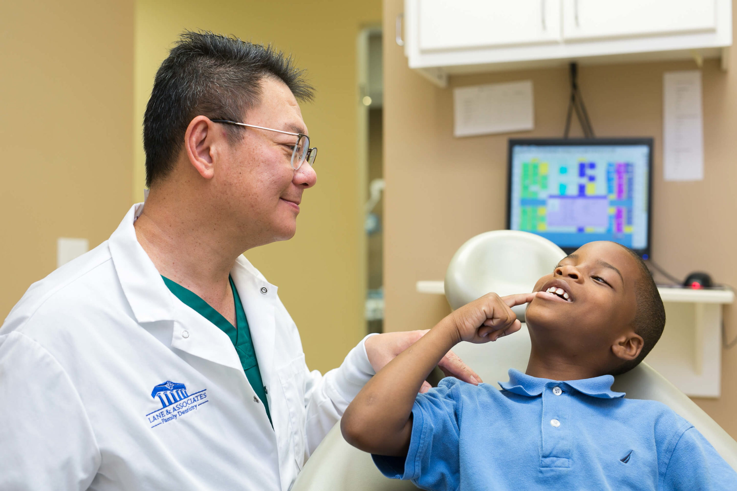 Boy showing dentist his tooth in dental chair