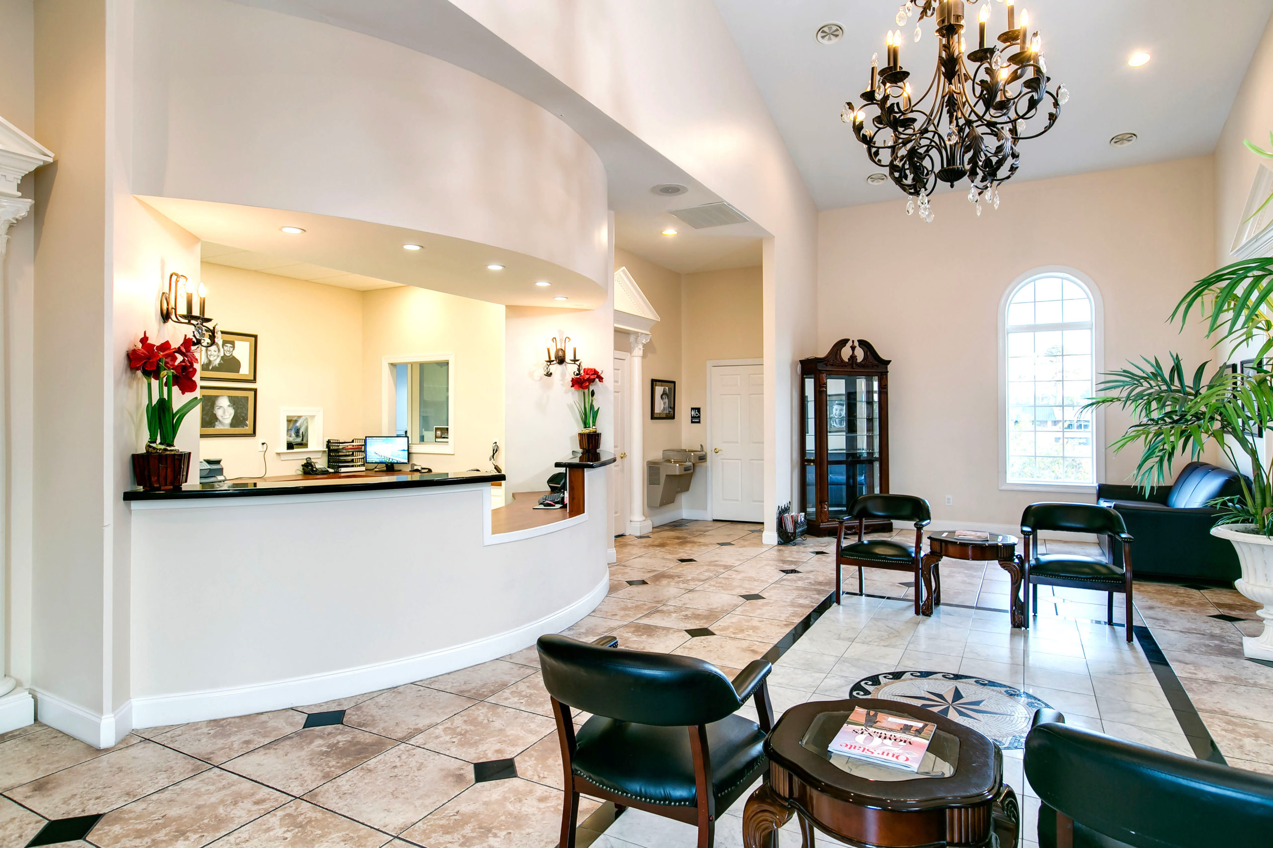 beautiful dental office lobby with chandelier white and cream walls dark brown furniture