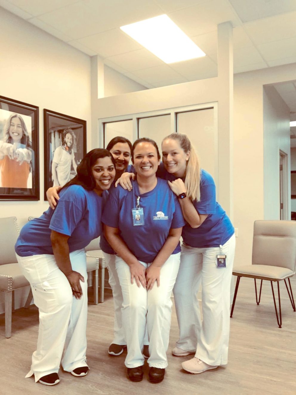 Mebane dentist office staff smiling for group shot in lobby