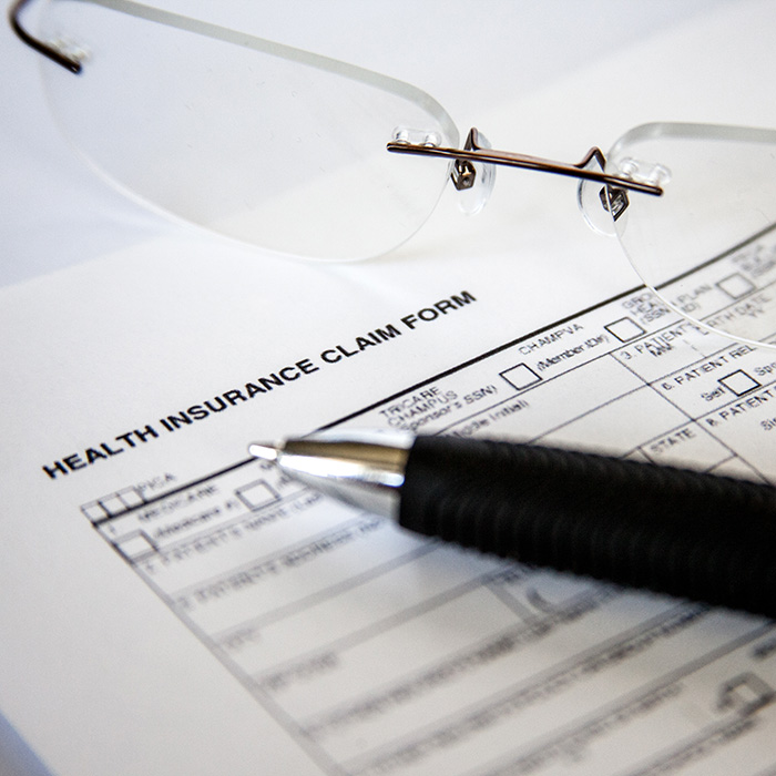 Insurance benefits breakdown with glasses and pen laying on top
