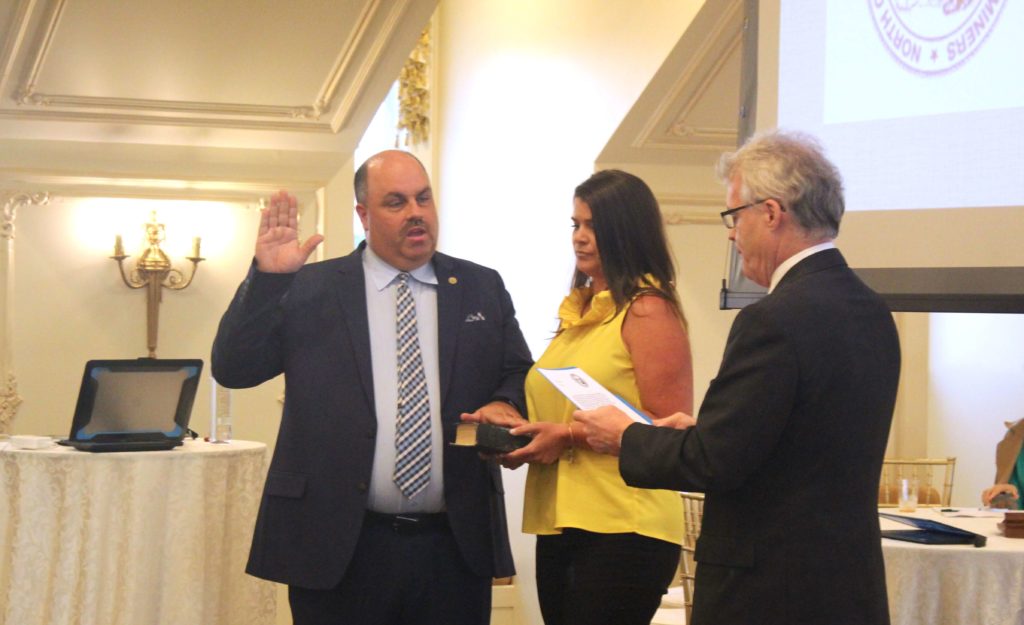 Dr. Raleigh Wright raising hand for induction ceremony