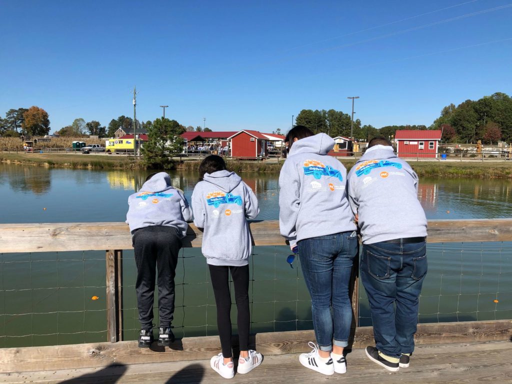 Family wearing matching hoodies by lake