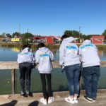 Family wearing matching hoodies by lake
