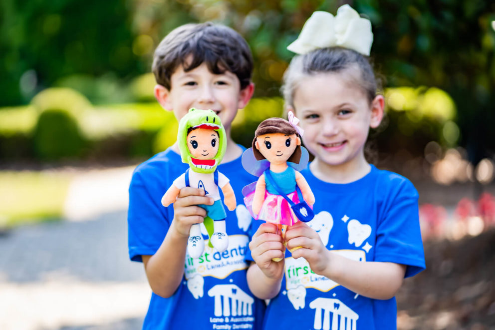 Two children holding First Dental Visit dolls
