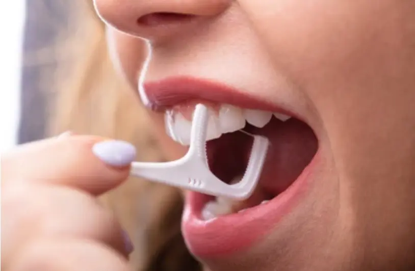 Woman using floss pick